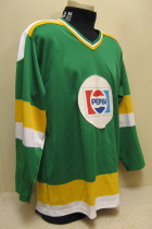 This green jersey with the Pepsi logo on it was used in the latter part of the 86-87 PeeWee A travel season. Worn by Cody Delperdang. The  white jerseys were a little more elaborate and they went through the season with only one set. The Team won the Midwest League tournament and advanced to the Central District Tier II tournament in St. Louis. Tournament rules dictated that two sets of jerseys so Dave Davies ordered the green ones and got the logo and numbers on them last minute. These were only wore those jerseys 2 games and  don't believe they were used for travel hockey next season. 
